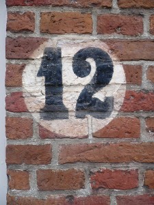 レンガの壁に白い丸の中に黒字で12と書かれている