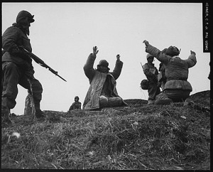 丘の上で銃を構える兵士と手を挙げる兵士