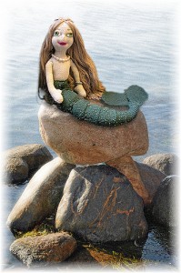 水辺の石の上にのるマーメイドの人形