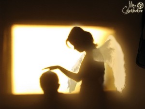 子供の頭に手をかざす天使の影